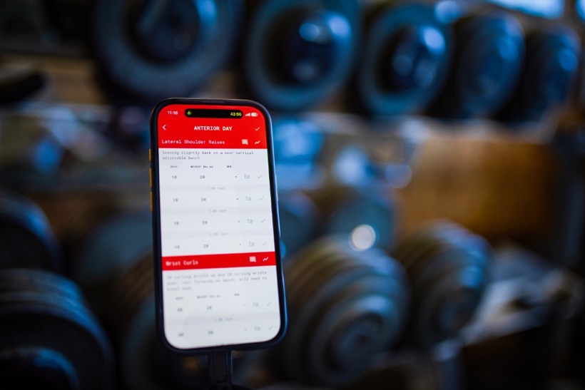 Trainer App workout on a phone in the gym